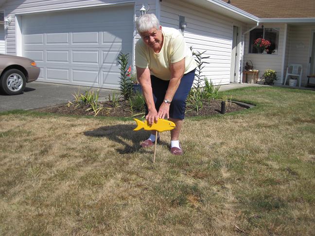 Donna Layon placing her yellow fish on her lawn